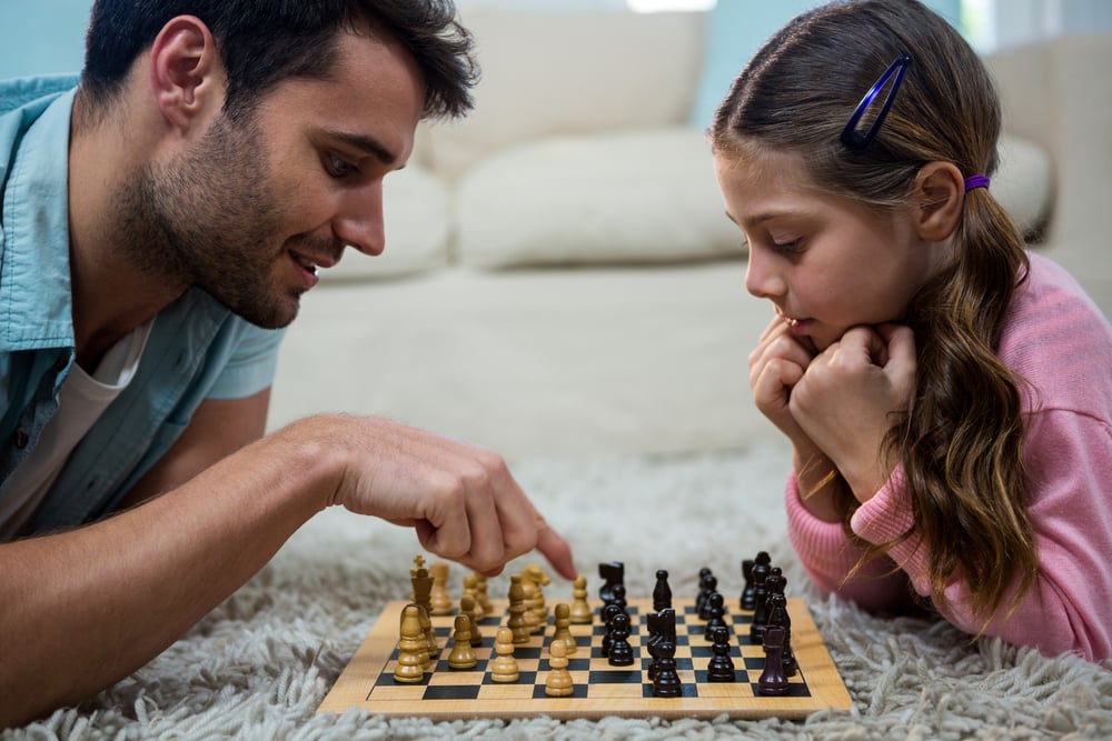 Picture of Dad and Child Playing Chess Strategizing about Work Comp
