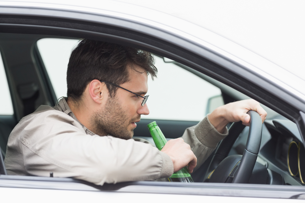 Man drinking beer while driving in his car